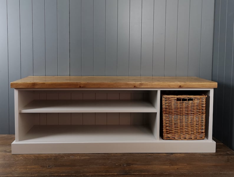 A large hallway or utility room shoe bench. Painted in french grey with a rustic antique pine top to sit on. A large willow basket for extra shoe storage is situated on the right and two shelves to the left.