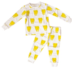 May include: White pajamas with a yellow chicken print. The pajamas have long sleeves and long pants.