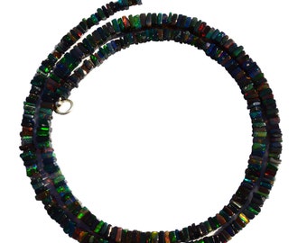 May include: A black opal necklace with a silver clasp. The necklace is made of small, square-shaped beads that are iridescent and have a variety of colors, including green, blue, and red.