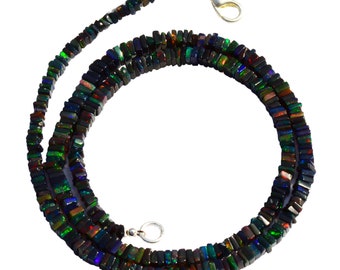 May include: A black opal necklace with silver clasps. The necklace is made of square-shaped beads with iridescent colors.