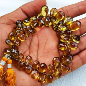 May include: A strand of faceted, teardrop-shaped, golden yellow gemstone beads. The beads are strung on a thin wire and have a natural, rustic look.