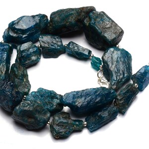 Puede incluir: Un collar hecho de piedras de apatita azul verdoso sin pulir. Las piedras son de forma y tama&ntilde;o irregulares, y est&aacute;n enhebradas en una cadena de plata.