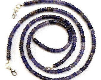 Könnte beinhalten: Eine lange Kette aus dunkelvioletten und hellvioletten Edelsteinperlen mit silbernen Verschlüssen. Die Perlen sind facettiert und haben eine leicht unregelmäßige Form.