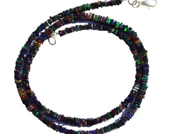 May include: A black opal gemstone necklace with a silver clasp. The necklace is made of square-shaped beads with iridescent colors.