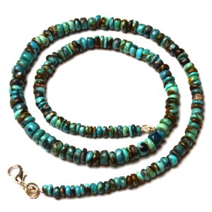 May include: A turquoise beaded necklace with a silver clasp. The necklace features small, round beads in shades of turquoise, brown, and green. The beads are strung together to form a necklace that can be worn around the neck.