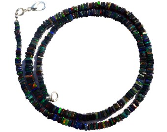 May include: A black opal necklace with a silver clasp. The necklace is made of square-shaped beads with iridescent colors, including green, blue, and red.