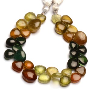 May include: A strand of green, yellow, and brown gemstone beads in a teardrop shape. The beads are strung on a cord and are ready to be made into jewelry.
