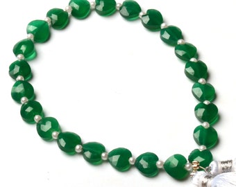 Puede incluir: Un collar de corazón de piedra preciosa verde con detalles de perlas blancas y borlas blancas.
