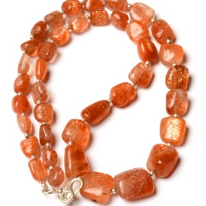 Può includere: Una collana realizzata con perline di pietra di sole arancione con una chiusura in argento.