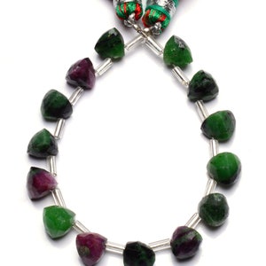 May include: A strand of green and pink gemstone beads with a silver clasp and green and red tassels.