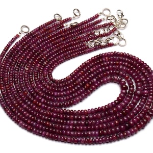 May include: A set of 10 strands of ruby red gemstone beads, each strand is approximately 18 inches long and features small, round beads. The beads are strung on silver-toned chains with lobster claw clasps.