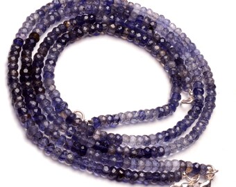 May include: A strand of blue and gray gemstone beads with silver clasps. The beads are faceted and have a slightly iridescent sheen.