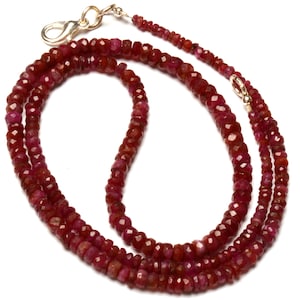 Puede incluir: Un collar de doble cadena hecho de cuentas de rubí rojo. El collar está hecho de cuentas pequeñas y facetadas y tiene un cierre de oro.