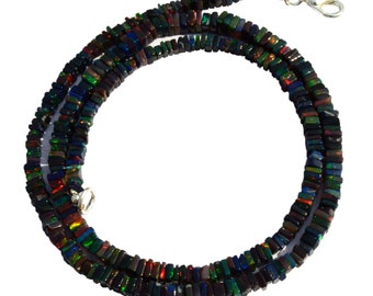 May include: A black opal necklace with a silver clasp. The necklace is made of square-shaped beads that are iridescent and have a rainbow of colors.