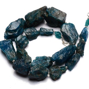 Puede incluir: Un collar hecho de piedras de apatita azul verdoso rugosas con cuentas de plata y un cierre de plata.