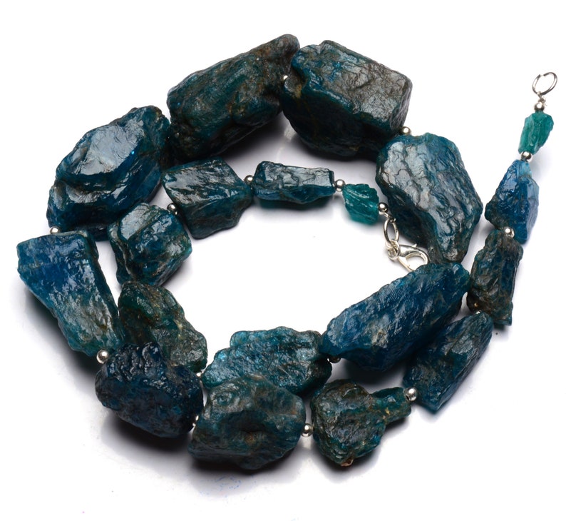 Puede incluir: Un collar hecho de piedras de apatita azul verdoso rugosas con cuentas de plata y un cierre de plata.