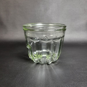 Peut inclure: Un pot en verre transparent avec un motif cannelé. Le pot a une large ouverture et un bord lisse.