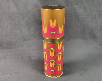May include: A gold and brown cylindrical bottle with a pink and orange floral design. The bottle has a gold cap.