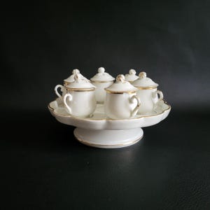 6 petits pots couverts à crème ou à jus sur leur plateau assorti en porcelaine blanche liseré or prise en forme de fruit vintage