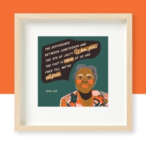 May include: A framed print with a teal background featuring a portrait of Opal Lee, a woman with glasses and a colorful patterned shirt. The quote "The difference between Juneteenth and the 4th of July? Who, girl! The fact is none of us are free till we're all free." is written in a speech bubble above her head.