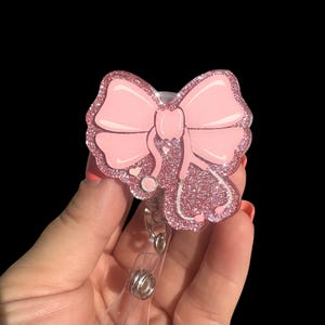 May include: Pink glitter badge reel with a pink bow and a stethoscope design.