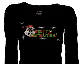 May include: Black long-sleeved top with a V-neck. It displays a Santa Claus design and the words "Merry Christmas!" in red, green, and white rhinestones. The design includes star accents.