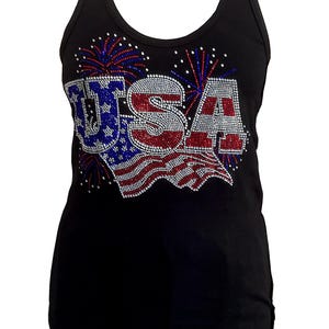 May include: Black tank top with the word "USA" in red, white, and blue rhinestones. The design includes a flag and fireworks. The tank top is sleeveless and has a scoop neck.