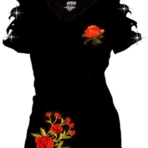 May include: Black t-shirt with distressed sleeves and red embroidered roses. The roses are on the front and bottom of the shirt.