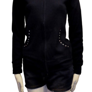May include: Black zip-up hoodie with a hood and long sleeves. The hoodie has a ribbed texture and silver studs on the sides.