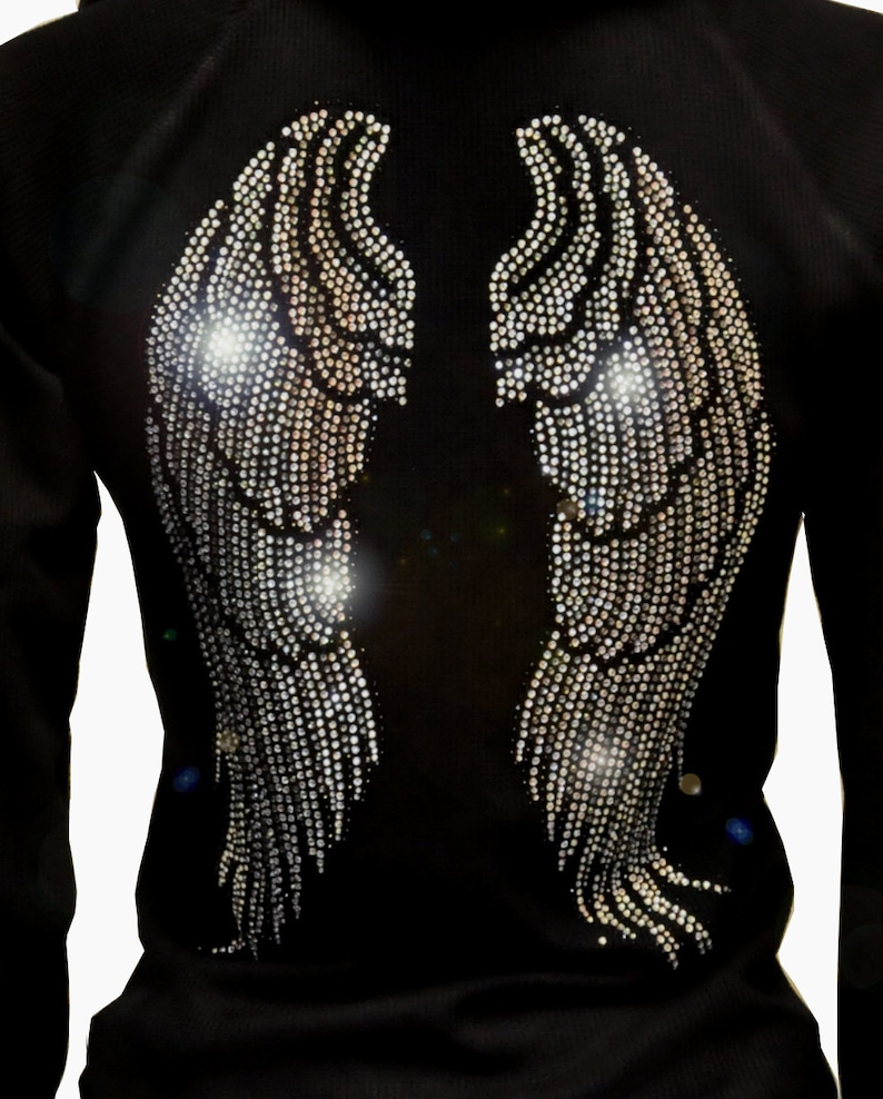 May include: Black long-sleeved shirt with a rhinestone design of angel wings on the back.
