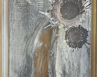 Puede incluir: Pintura abstracta en un marco plateado. La pintura presenta un fondo texturizado con una forma vertical marrón en el centro. Hay dos círculos negros con acentos dorados en la esquina superior derecha.