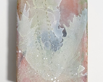 Puede incluir: Pintura abstracta sobre un lienzo rectangular. El fondo es de color rosa claro con salpicaduras de pintura blanca y gris. El centro de la pintura presenta una gran forma abstracta blanca y gris.