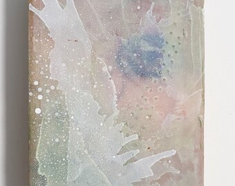 Puede incluir: Pintura abstracta sobre una baldosa de cerámica. El fondo es rosa claro con salpicaduras blancas y verdes. También hay pequeños puntos azules y blancos en toda la pintura.