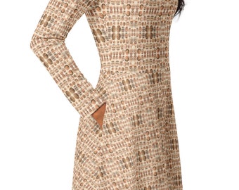 Puede incluir: Un vestido de manga larga con fondo beige y un patrón de muchas caras. El vestido tiene un bolsillo en el lado izquierdo.