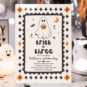 May include: A rectangular Halloween party invitation card with a cream background, black scalloped border, and orange diamond accents. It features a ghost holding a pumpkin, stars, a bat, and text reading: trick or three, William's 3rd boo-day.