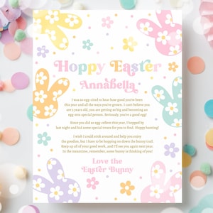 May include: An Easter card in pastel shades with the message "Hoppy Easter Annabella". The design includes bunny and flower illustrations in yellow, pink, blue, and purple. The background features confetti and a pink paper fan.