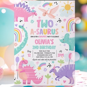 May include: A colorful dinosaur-themed birthday party invitation for a girl's 2nd birthday. The invitation features a pink dinosaur, a blue dinosaur, and a rainbow. The text on the invitation reads "Two A-saurus Join us for a Dinomite Party to Celebrate Olivia's 2nd Birthday".