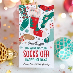 May include: A white gift tag with a colorful illustration of Christmas stockings and the text "Thank you for working your socks off! Happy Holidays from the Miller family."