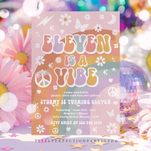 May include: A pink and rainbow-colored invitation for an 11th birthday party. The invitation features the text "Eleven is a Vibe" in a retro font. The invitation also includes a peace sign, flowers, and butterflies. The text "Come celebrate peace, love and fun our groovy Stormy is turning eleven" is included. The date, time, and location of the party are also listed. RSVP information is included at the bottom of the invitation.