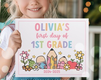May include: A white sign with a pink border, held by a child, reads "OLIVIA'S first day of 1ST GRADE" in pastel colors. The sign features illustrations of pencils, flowers, and an apple, with the year 2024-2025 at the bottom.