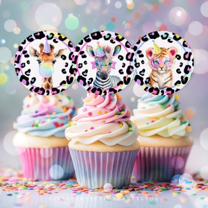 Puede incluir: Tres cupcakes decorados con chispas de colores y coronados con toppers redondos de papel para cupcakes que representan una jirafa, una cebra y un tigre con sombreros de fiesta. Los toppers tienen un fondo de estampado de leopardo con acentos de arcoíris.