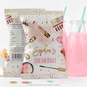 May include: Two custom chip bags with makeup illustrations and the text "Sophia's 13th Birthday". The bags feature a nutrition facts label with fun ingredients. A bottle of pink liquid with a straw is next to the bags.