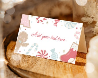 May include: A white place card with a pink gingerbread man, candy canes, and candy. The text "Add your text here" is printed in pink.