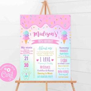 May include: A pink and purple first birthday sign with ice cream cone graphics. The sign includes the name "Madison" and details about the child's birth, including weight (9.5 kg) and height (76 cm).