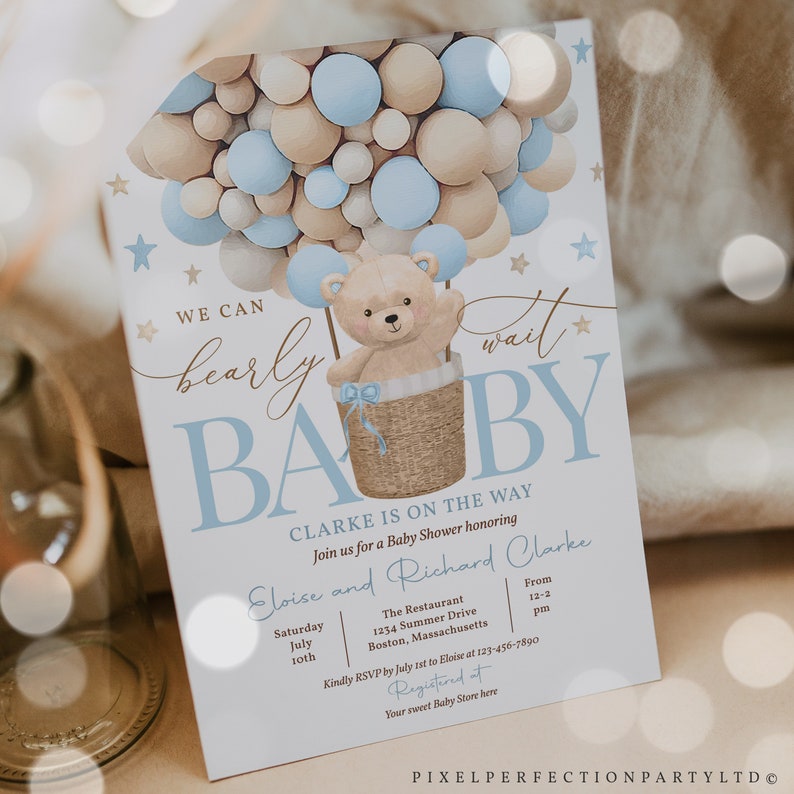Peut inclure: Une invitation de f&ecirc;te pr&eacute;natale avec un th&egrave;me bleu et beige. L'invitation repr&eacute;sente un ours en peluche dans un ballon &agrave; air chaud compos&eacute; de ballons bleus et beiges. Le texte sur l'invitation indique "We can barely wait" et "Baby". L'invitation comprend &eacute;galement les noms "Eloise et Richard Clarke" ainsi que la date et l'heure de la f&ecirc;te.