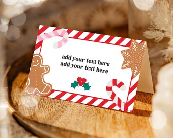 May include: Red and white striped place card with a gingerbread man, candy cane, holly, and a gingerbread star. The text on the card says "add your text here add your text here".