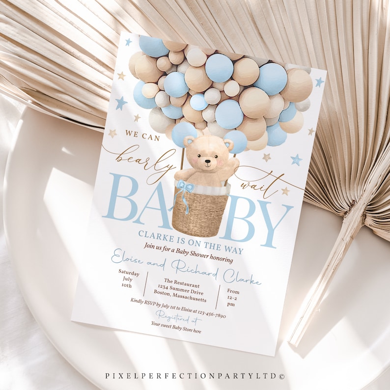 Peut inclure: Une invitation de f&ecirc;te pr&eacute;natale avec un th&egrave;me bleu et beige. L'invitation repr&eacute;sente un ours en peluche dans un panier, entour&eacute; de ballons. Le texte sur l'invitation est "We can barely wait Baby Clarke is on the way".