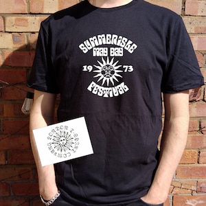 May include: Black t-shirt with a white graphic of a sun with a face and the text "Summerisle May Day 1973 Festival".