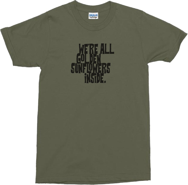 Puede incluir: Una camiseta verde con el texto "We're all golden sunflowers inside."
