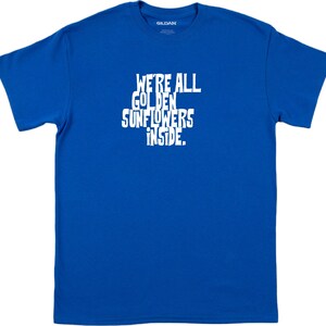 Puede incluir: Una camiseta azul real con texto blanco que dice "We're all golden sunflowers inside."